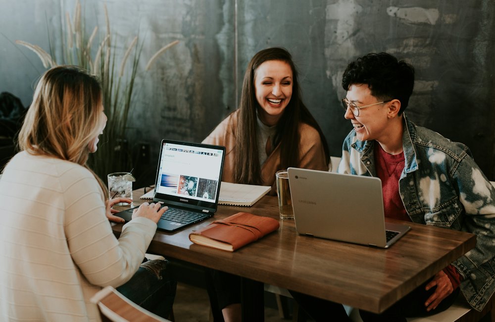 Drie mensen werken samen aan een tafel